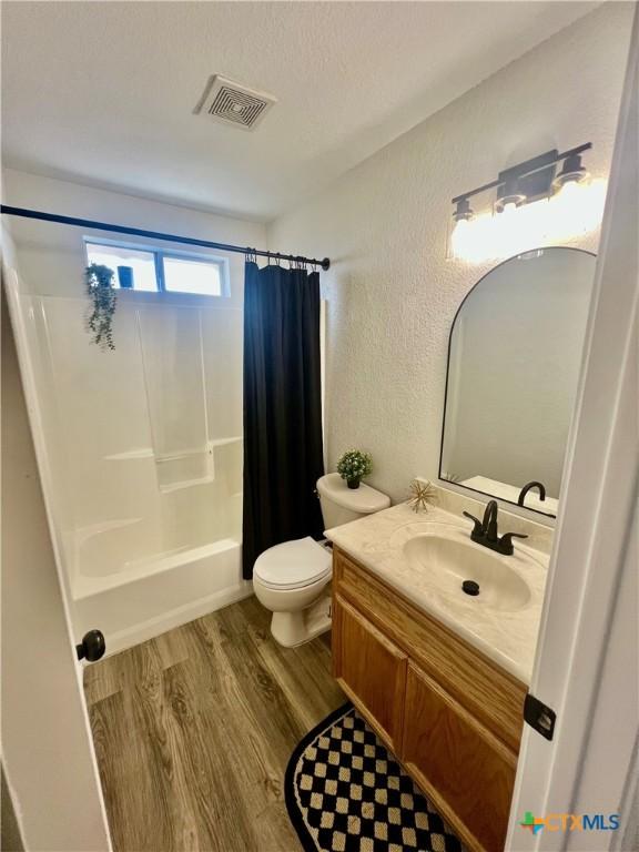 full bathroom featuring vanity, toilet, shower / bath combo with shower curtain, and wood-type flooring