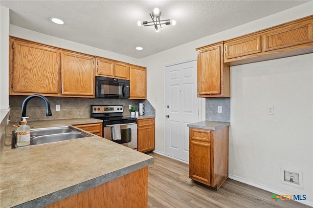 kitchen with a chandelier, tasteful backsplash, light wood-type flooring, stainless steel electric range, and sink