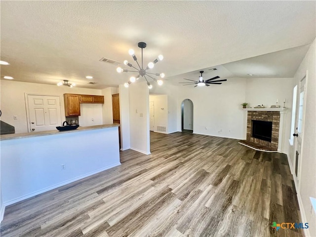 unfurnished living room featuring hardwood / wood-style floors, vaulted ceiling, and ceiling fan with notable chandelier