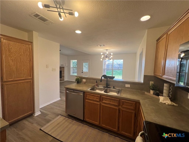 kitchen with a chandelier, appliances with stainless steel finishes, a textured ceiling, dark hardwood / wood-style flooring, and sink