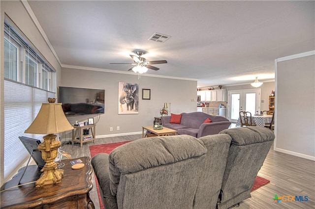 living room with wood-type flooring, ornamental molding, french doors, and ceiling fan