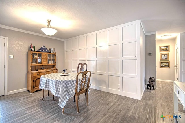 dining area with light hardwood / wood-style flooring, ornamental molding, and a textured ceiling