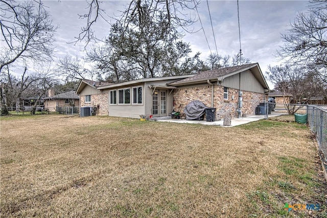 back of house featuring central AC, a patio, and a lawn