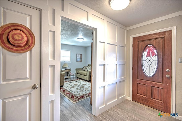 entryway featuring light hardwood / wood-style flooring and a textured ceiling