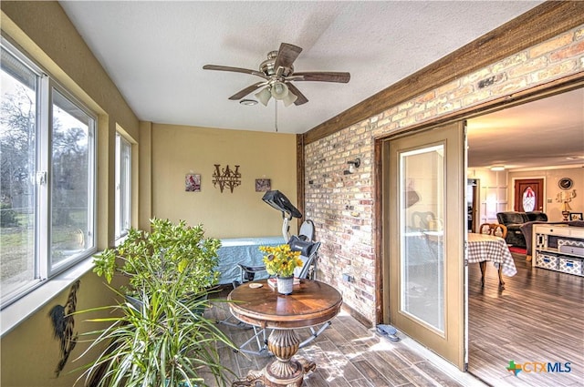 sunroom / solarium featuring plenty of natural light and ceiling fan