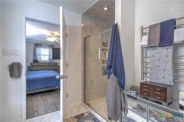 bathroom featuring a shower with door and ceiling fan