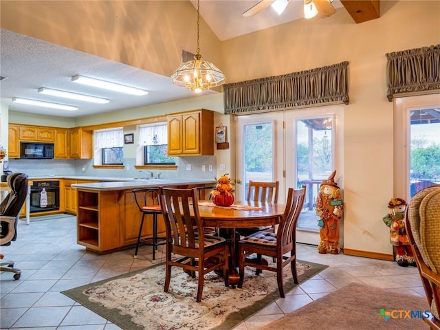 dining area with ceiling fan with notable chandelier, a healthy amount of sunlight, and light tile patterned flooring