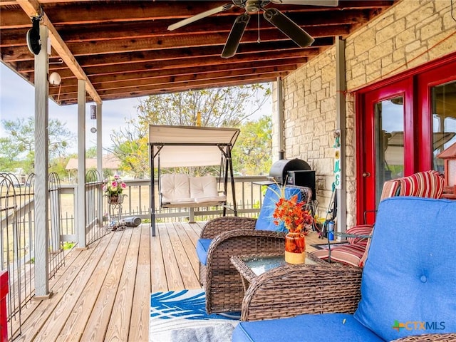 wooden terrace featuring grilling area and ceiling fan