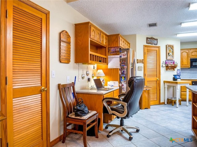 tiled office featuring a textured ceiling