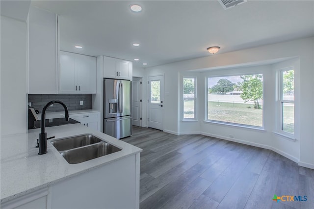 575 Live Oak Dr, Bertram, TX 78605 - kitchen featuring stainless steel refrigerator with ice dispenser, plenty of natural light, wood finished floors, decorative backsplash, and recessed lighting