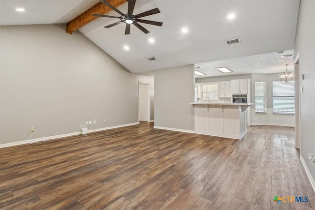 unfurnished living room featuring ceiling fan with notable chandelier, baseboards, dark wood-type flooring, and visible vents