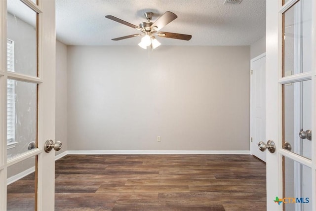 empty room with french doors, a ceiling fan, a textured ceiling, and wood finished floors