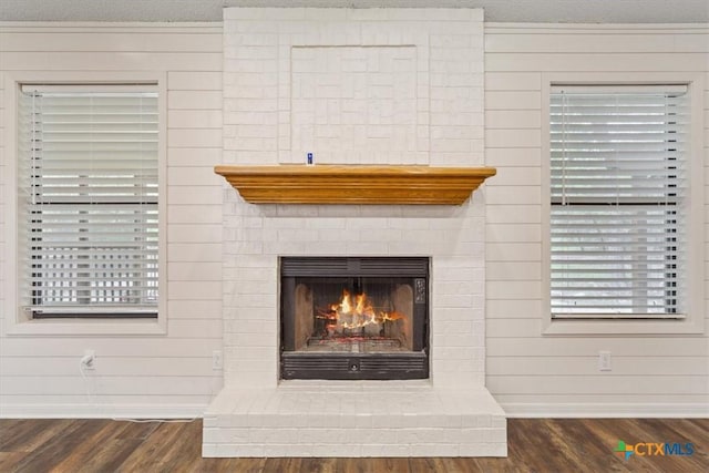 details with baseboards, a fireplace, wood finished floors, and a textured ceiling