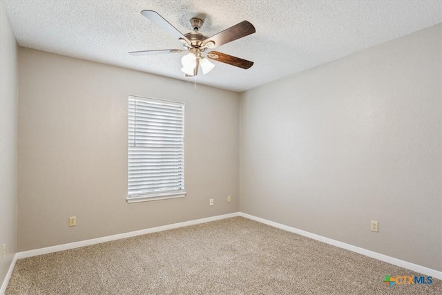 carpeted spare room with baseboards, ceiling fan, and a textured ceiling