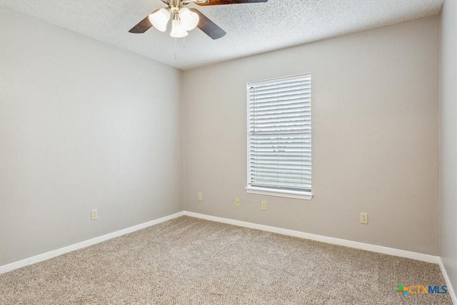 spare room featuring carpet, baseboards, a textured ceiling, and ceiling fan