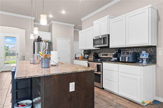 2635 Bolzano Trl, Temple, TX 76502 - kitchen with stainless steel appliances, crown molding, tasteful backsplash, light stone countertops, and white cabinetry