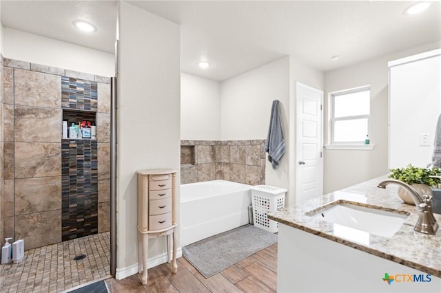 2635 Bolzano Trl, Temple, TX 76502 - full bathroom with a garden tub, wood finished floors, a fireplace, a tile shower, and vanity