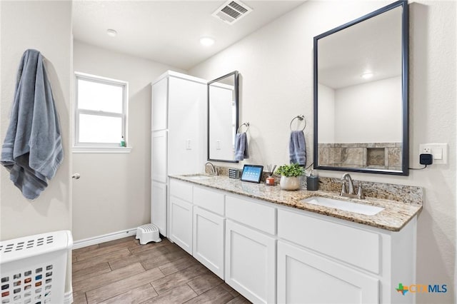 2635 Bolzano Trl, Temple, TX 76502 - full bathroom with wood finished floors, double vanity, and baseboards