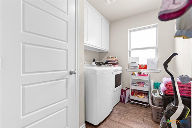 2635 Bolzano Trl, Temple, TX 76502 - laundry room featuring washing machine and clothes dryer, cabinet space, and light wood-style flooring