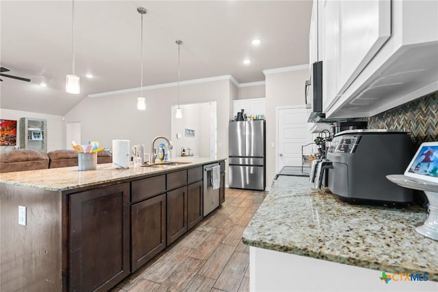 2635 Bolzano Trl, Temple, TX 76502 - kitchen featuring appliances with stainless steel finishes, a sink, dark brown cabinets, a kitchen island with sink, and open floor plan