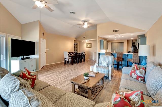 living room featuring ceiling fan, light hardwood / wood-style floors, and lofted ceiling