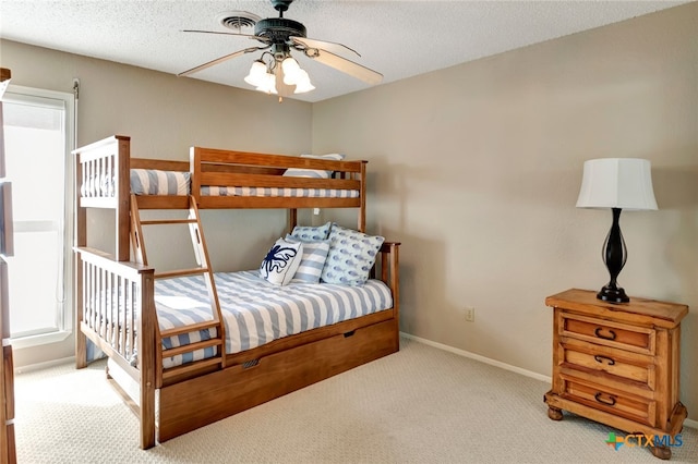 carpeted bedroom featuring a textured ceiling and ceiling fan