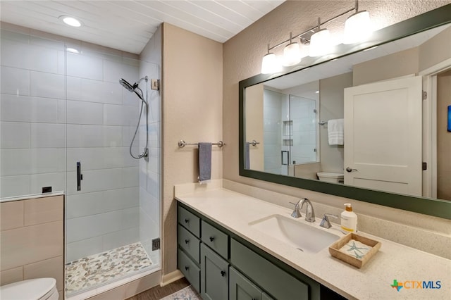 bathroom featuring hardwood / wood-style floors, vanity, toilet, and an enclosed shower