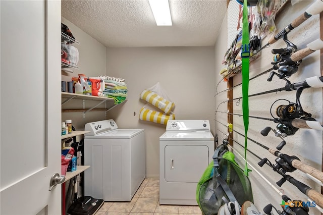 laundry room featuring light tile patterned floors, washer and dryer, and a textured ceiling