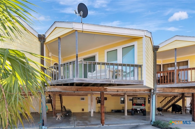 back of house with a carport and a balcony