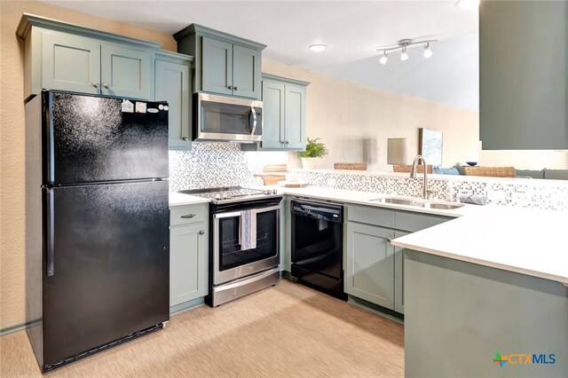 kitchen featuring black appliances, backsplash, kitchen peninsula, and sink