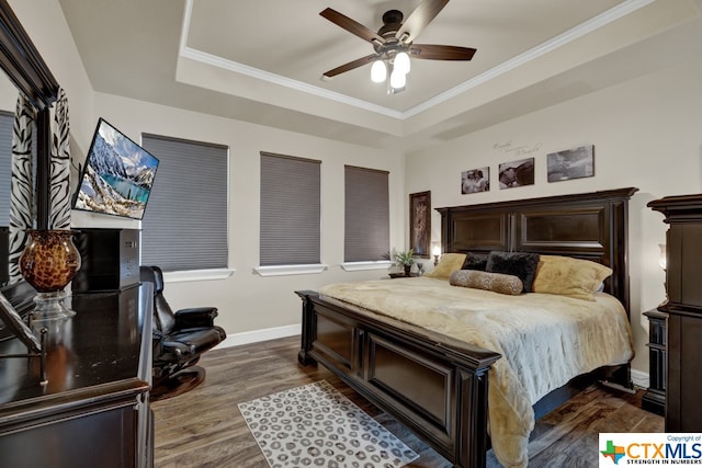 bedroom featuring dark hardwood / wood-style floors, crown molding, ceiling fan, and a raised ceiling