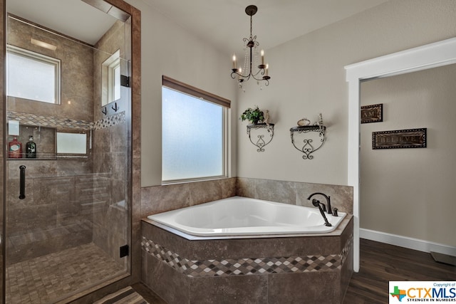 bathroom with hardwood / wood-style floors, plenty of natural light, a notable chandelier, and separate shower and tub