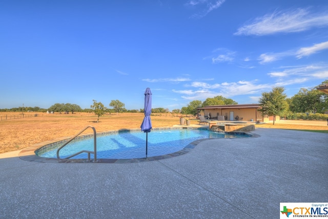 view of pool featuring a patio and an in ground hot tub