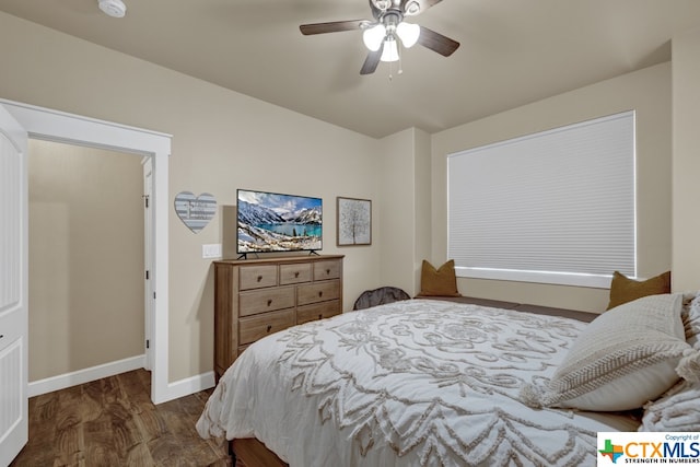 bedroom with dark hardwood / wood-style flooring and ceiling fan