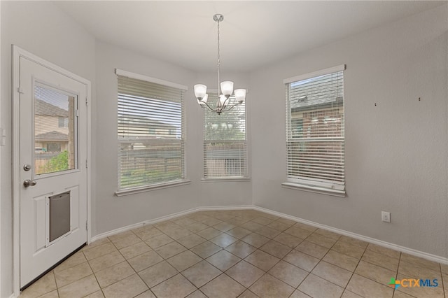 unfurnished dining area featuring light tile patterned flooring and a notable chandelier