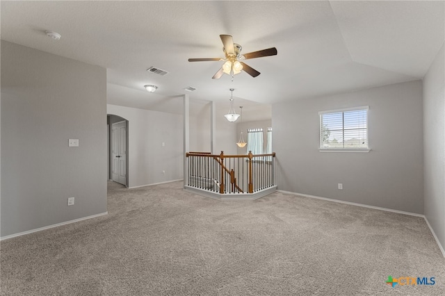 carpeted empty room with ceiling fan and vaulted ceiling