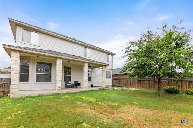 back of house featuring a yard and a patio area