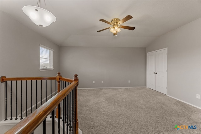 carpeted empty room with vaulted ceiling and ceiling fan