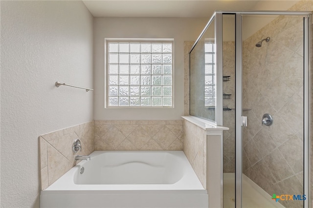 bathroom featuring shower with separate bathtub