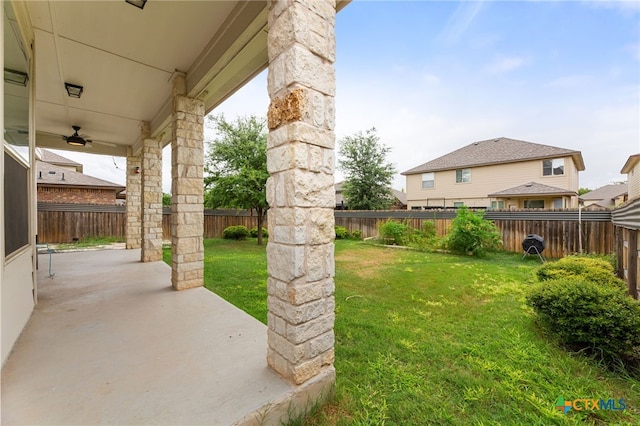 view of yard with ceiling fan and a patio area