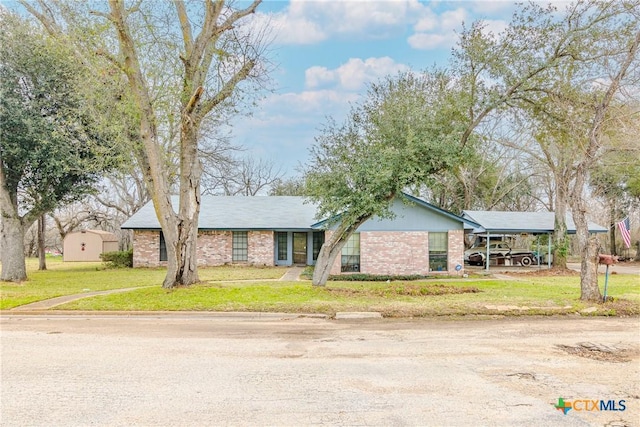 ranch-style home with a carport and a front lawn