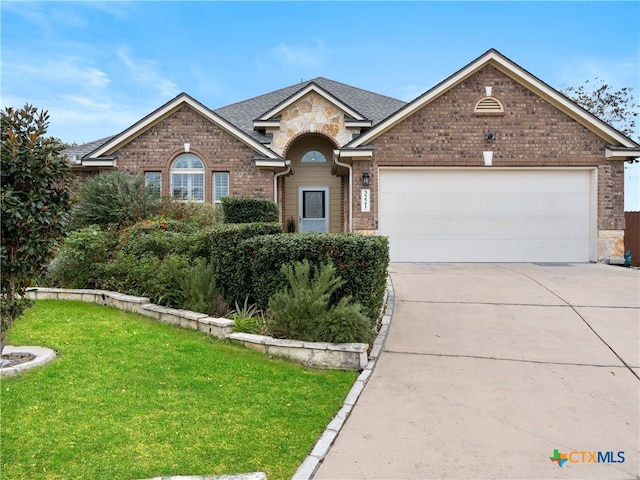 view of front of house with a front yard and a garage