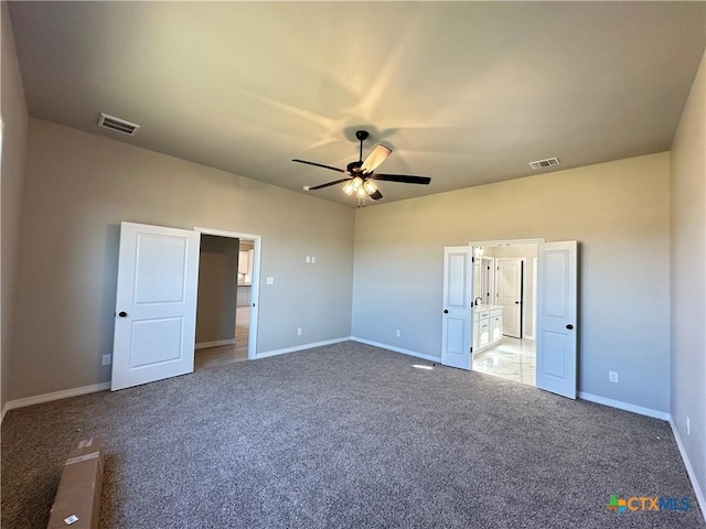 unfurnished bedroom with carpet flooring, ensuite bathroom, and ceiling fan