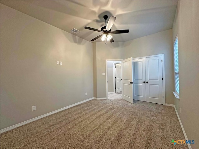 unfurnished bedroom with light carpet, a closet, and ceiling fan