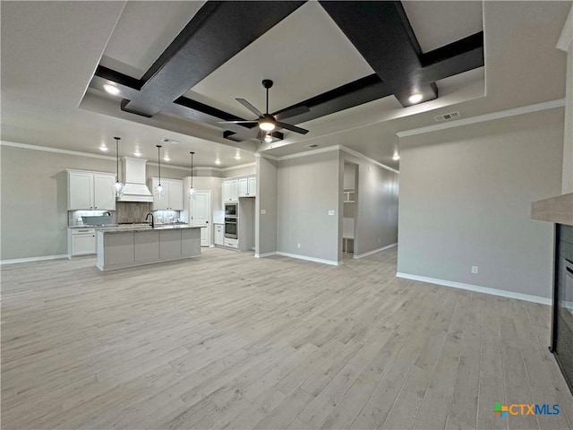 unfurnished living room featuring ceiling fan, coffered ceiling, crown molding, and light wood-type flooring