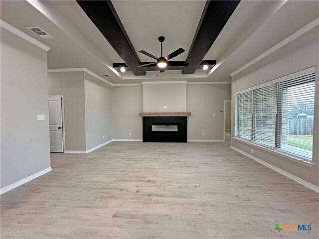 unfurnished living room featuring light hardwood / wood-style flooring, a raised ceiling, ceiling fan, and crown molding