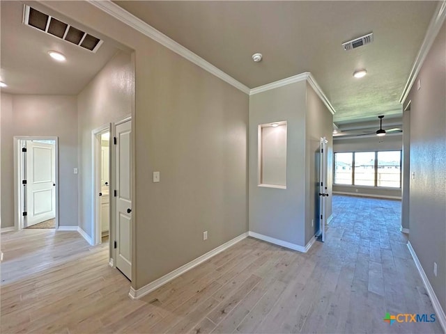 hallway with light hardwood / wood-style floors and ornamental molding