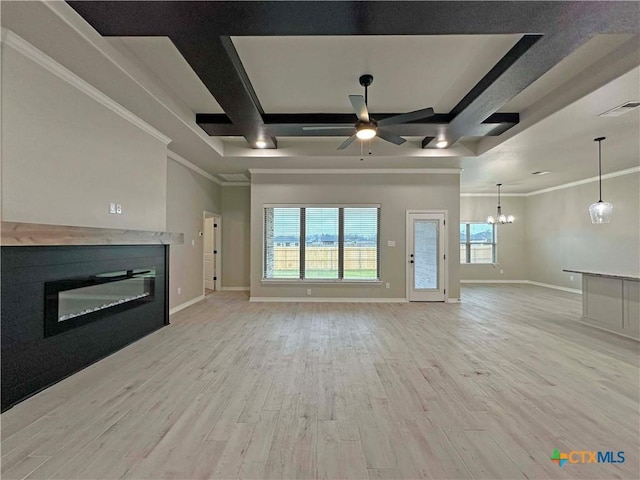 unfurnished living room featuring ceiling fan with notable chandelier, ornamental molding, light hardwood / wood-style floors, and a raised ceiling