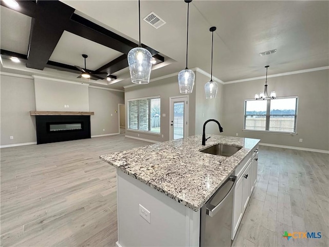 kitchen with stainless steel dishwasher, sink, a center island with sink, and white cabinets