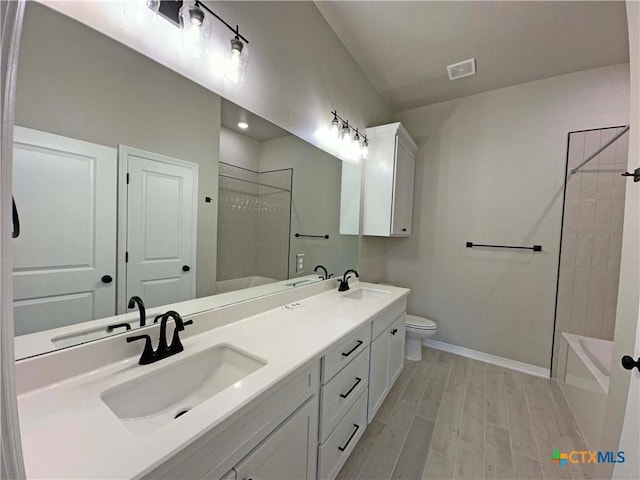 full bathroom with vanity, tiled shower / bath combo, and toilet